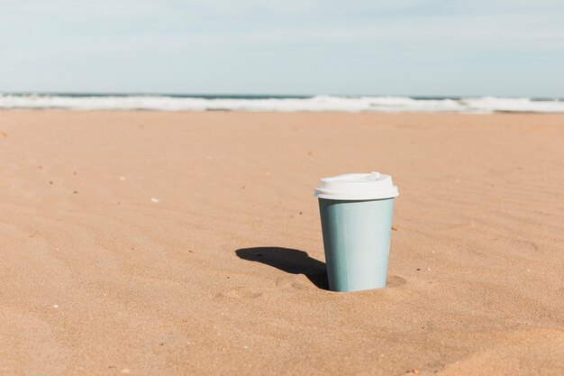 Koncepcja plaży z filiżanki papierowej