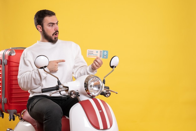 Koncepcja Podróży Z Zaskoczonym Mężczyzną Siedzącym Na Motocyklu Z Walizką Na Nim Pokazującym Bilet Na żółto