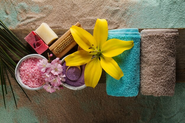 Koncepcja Spa. Widok z góry pięknych produktów spa z miejscem na tekst. Olejek eteryczny z pięknymi kwiatami, ręczniki, sól do kąpieli i ręcznie robione mydło.
