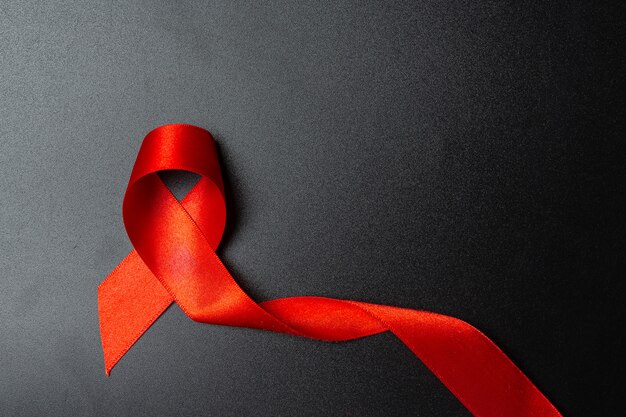 Koncepcja świadomości HIV z czerwoną wstążką Światowy Dzień Walki z AIDS i Światowy Dzień Zdrowia Seksualnego.