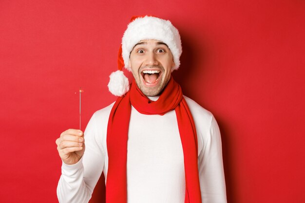 Koncepcja świątecznych ferii zimowych i uroczystości zbliżenie szczęśliwego przystojnego mężczyzny w santa hat i ...