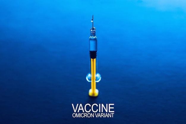 Koncepcja szczepionki nowej generacji przeciwko południowoafrykańskiej odmianie koronawirusa. omikronowy wariant sars-cov-2. fiolki z lekami i strzykawką na niebieskim szklanym stole z tłem okna.