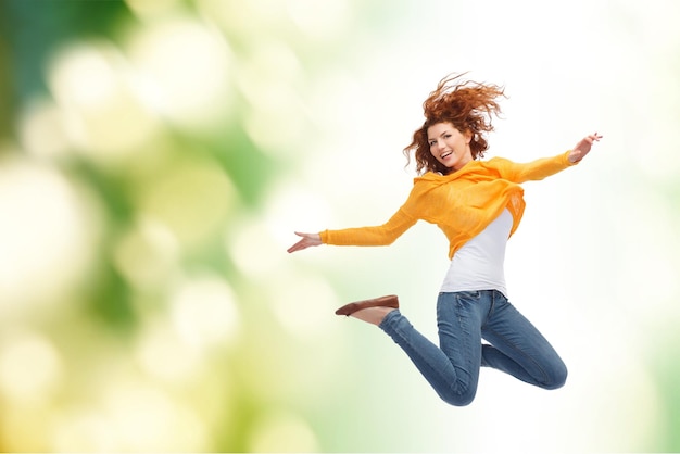 Koncepcja Szczęścia, Wolności, Ruchu I Ludzi - Uśmiechnięta Młoda Kobieta Skacząca Wysoko W Powietrze Nad Zielonym Tłem Premium Zdjęcia
