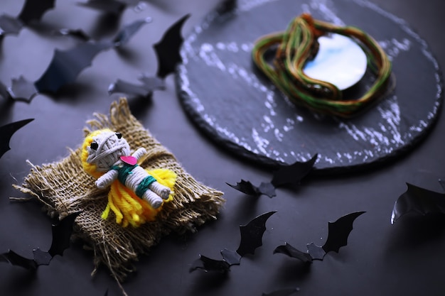 Koncepcja wakacje halloween. stary kamienny stół w kształcie nietoperzy. halloweenowe papierowe dekoracje na ciemnym tle. zabawka księżycowa.