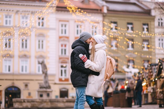 Koncepcja wakacji, zimy, bożego narodzenia i ludzi - szczęśliwa para w ciepłych ubraniach spacerująca po starym mieście
