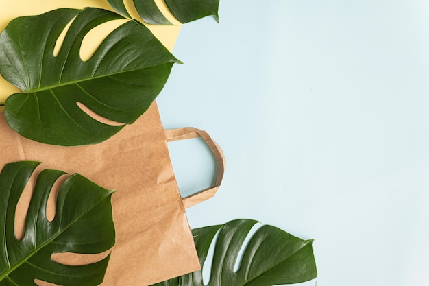 Koncepcja zakupów Flat Lay z papierową torbą i tropikalnymi liśćmi