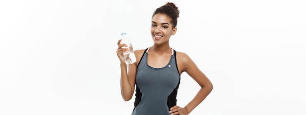Koncepcja Zdrowego I Fitness Piękna African American Girl W Ubrania Sportowe Trzymając Plastikową Butelkę Wody Po Treningu Izolowany Na Białym Tle Studio
