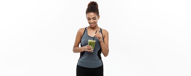 Koncepcja zdrowego i fitness piękna amerykańska pani z Afryki w odzieży fitness pije zdrowy ve