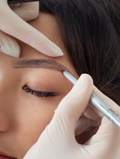 Bezpłatne zdjęcie kosmetyczka wykonująca zabieg microblading na brwiach klienta