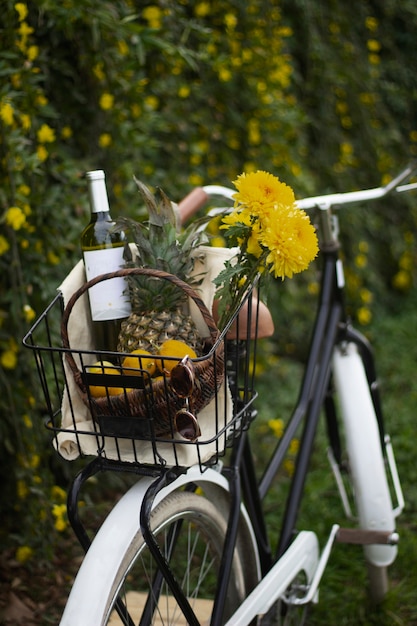 Kosz rowerowy z pięknymi kwiatami i butelką