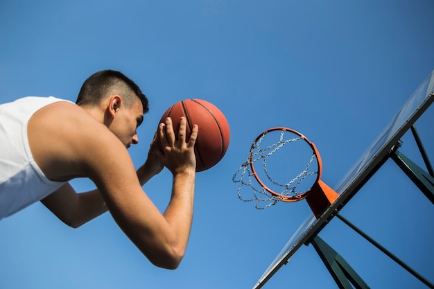 Bezpłatne zdjęcie koszykarz rzuca piłkę do siatki