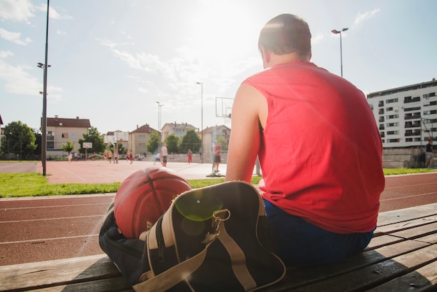 Koszykarz siedzi na boisku sportowym