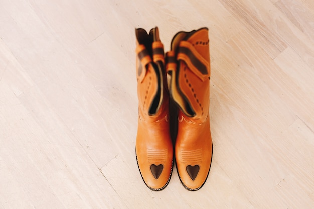 Kowbojskie buty stoją na drewnianej podłodze