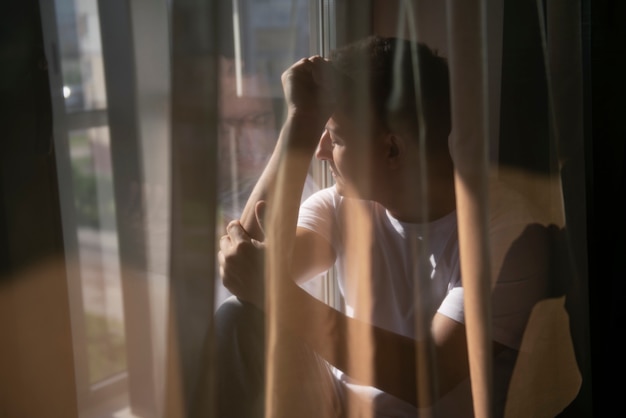 Bezpłatne zdjęcie kreatywny portret mężczyzny z zasłonami i cieniami z okna