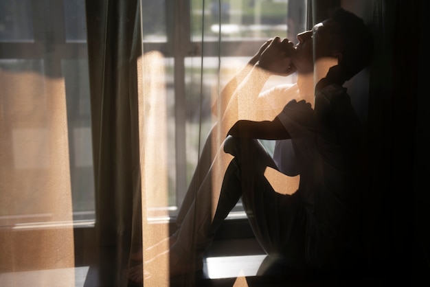 Kreatywny portret mężczyzny z zasłonami i cieniami z okna