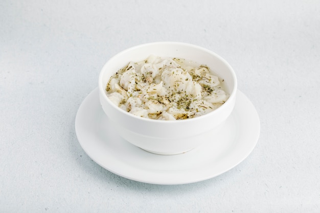 Kremowa zupa grzybowa z przyprawami w białej misce.