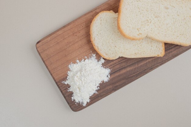 Krojony biały chleb z mąką na desce