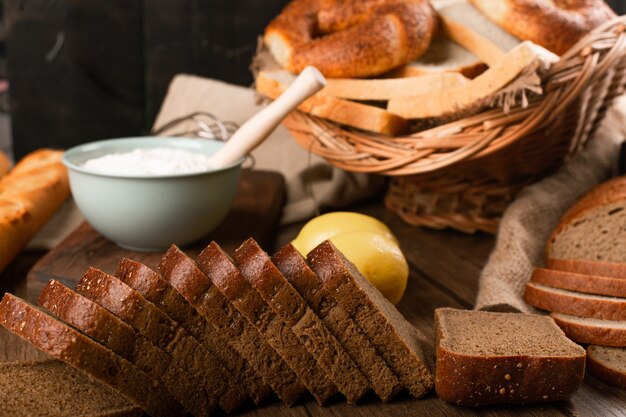 Kromki chleba z bułkami i miską mąki