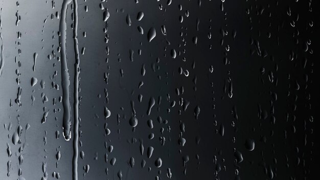 Krople deszczu na szklanym czarnym tle