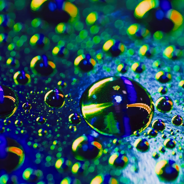 Krople wody na powierzchni z błyszczącym kolorowe odbicie
