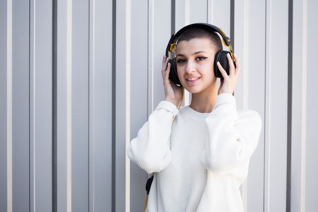 Bezpłatne zdjęcie krótkowłosa kobieta słucha muzyki ze słuchawkami
