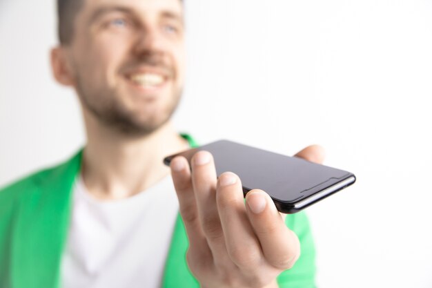 Kryty portret atrakcyjnego młodego mężczyzny trzymającego smartfona