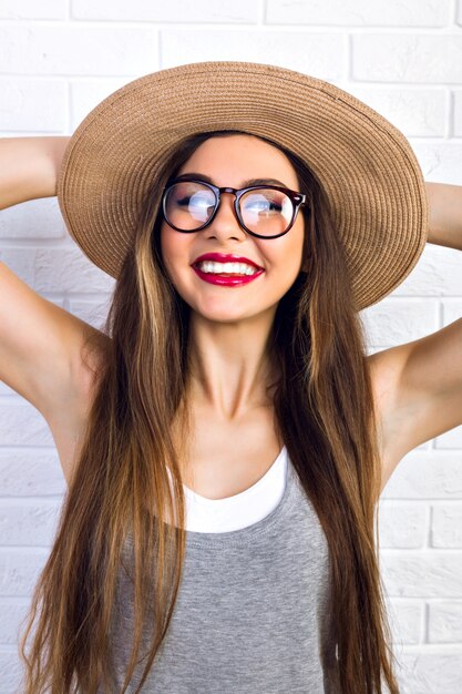 Kryty portret ładny słodki całkiem młoda kobieta w słomkowym kapeluszu i okularach, gotowy na letnie wakacje, pozytywne emocje, radość, zabawa.