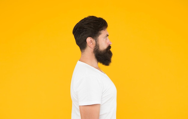Krzaczasta broda hipster człowiek fryzjer klienta żółte tło, koncepcja doskonały widok z boku.