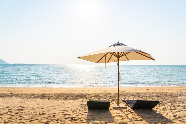 Krzesło parasol i hol na pięknym plażowym dennym oceanie na niebie