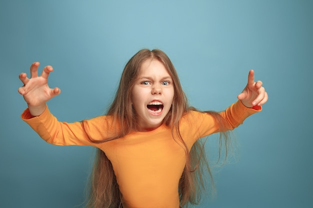 Bezpłatne zdjęcie krzyczeć zaskoczona dziewczyna nastolatka na niebieskim tle studia. wyraz twarzy i koncepcja emocji ludzi.