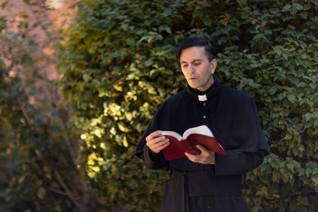Ksiądz czytający Biblię