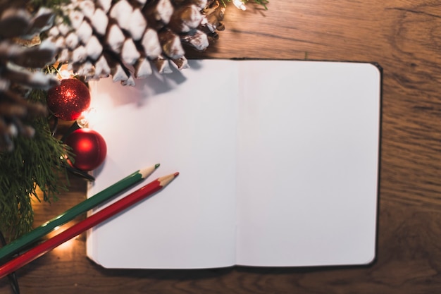 Książka, ołówki i świąteczne dekoracje