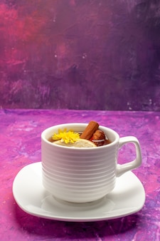 Kubek herbaty z widokiem z góry ze składnikami takimi jak cynamon i cytryna na różu w kształcie pionowym