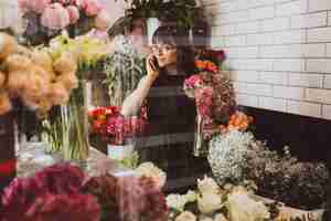 Bezpłatne zdjęcie kwiaciarnia kobieta na jej własny sklep kwiatowy dbanie o kwiaty