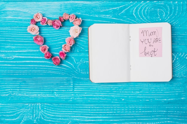 Bezpłatne zdjęcie kwiatowy ornament i otwarty notebook na dzień matki