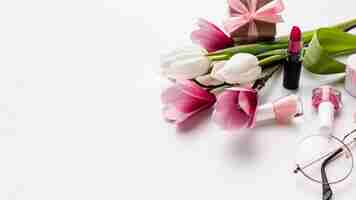 Bezpłatne zdjęcie kwiaty i kobiece przedmioty na białym tle