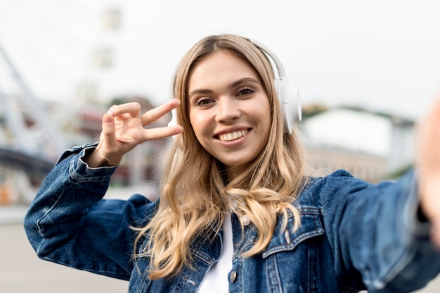 Bezpłatne zdjęcie Ładna blondynka biorąc selfie widok z przodu