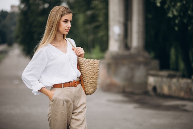 Ładna blondynki kobieta jest ubranym lata spojrzenie w parku