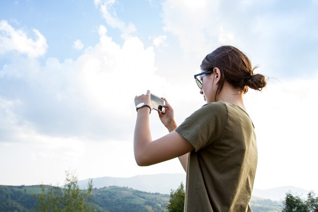 Ładna brunetki kobieta podróżuje, bierze fotografię piękny góra widok