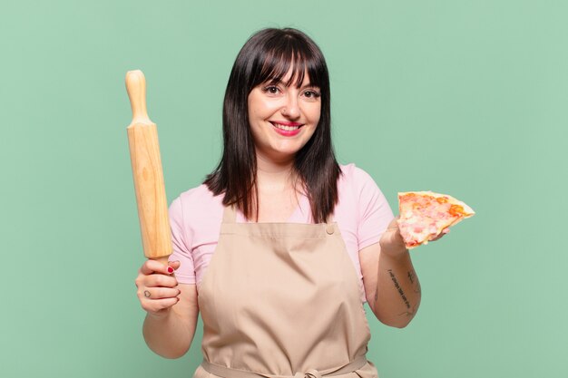 Ładna kobieta kucharz szczęśliwy wyraz twarzy i trzymająca pizzę