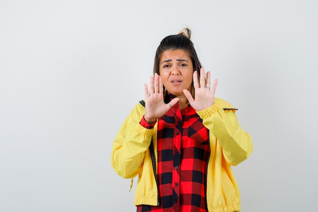 Bezpłatne zdjęcie Ładna kobieta pokazuje gest stop w koszulę, kurtkę i przestraszony. przedni widok.