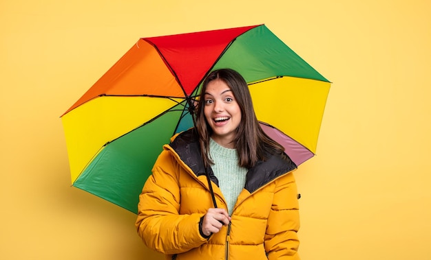 Ładna kobieta wygląda na szczęśliwą i mile zaskoczoną. koncepcja zima i parasol
