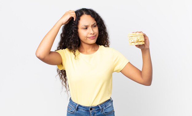 Ładna latynoska kobieta trzymająca ciastka z dietą ryżową