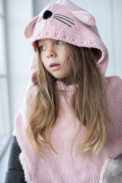 Ładna mała dziewczynka jest ubranym różowego pulower