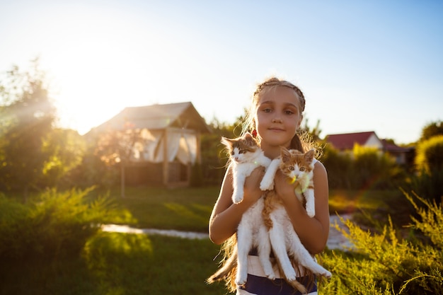 Bezpłatne zdjęcie Ładna młoda dziewczyna trzyma kocięta, uśmiechając się