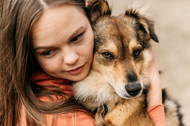 Bezpłatne zdjęcie Ładna młoda kobieta pieści swojego psa
