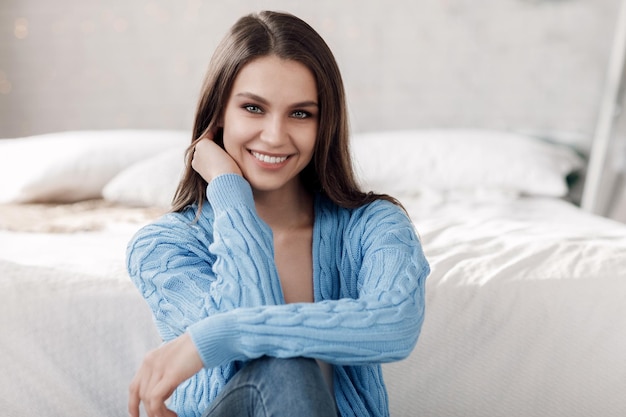 Bezpłatne zdjęcie Ładna młoda uśmiechnięta kobieta w pomieszczeniu