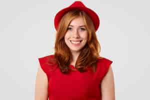 Bezpłatne zdjęcie Ładna modelka z pozytywnym uśmiechem ubrana w elegancki czerwony kapelusz i bluzkę, na randkę z chłopakiem