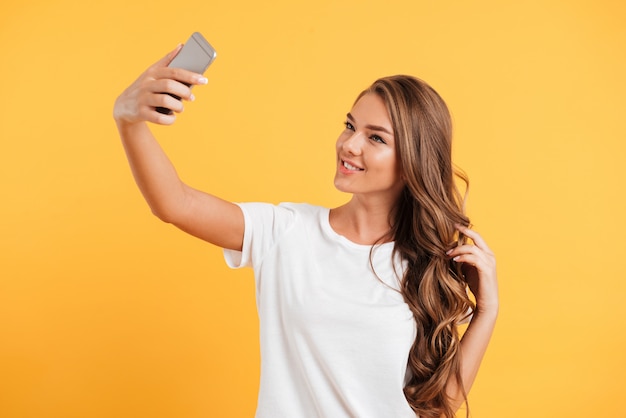 Ładna śliczna piękna młoda kobieta robi selfie telefonem komórkowym