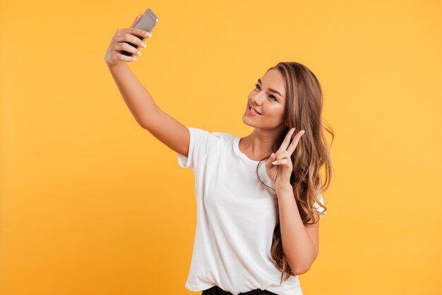 Ładna śliczna piękna młoda kobieta robi selfie telefonem komórkowym